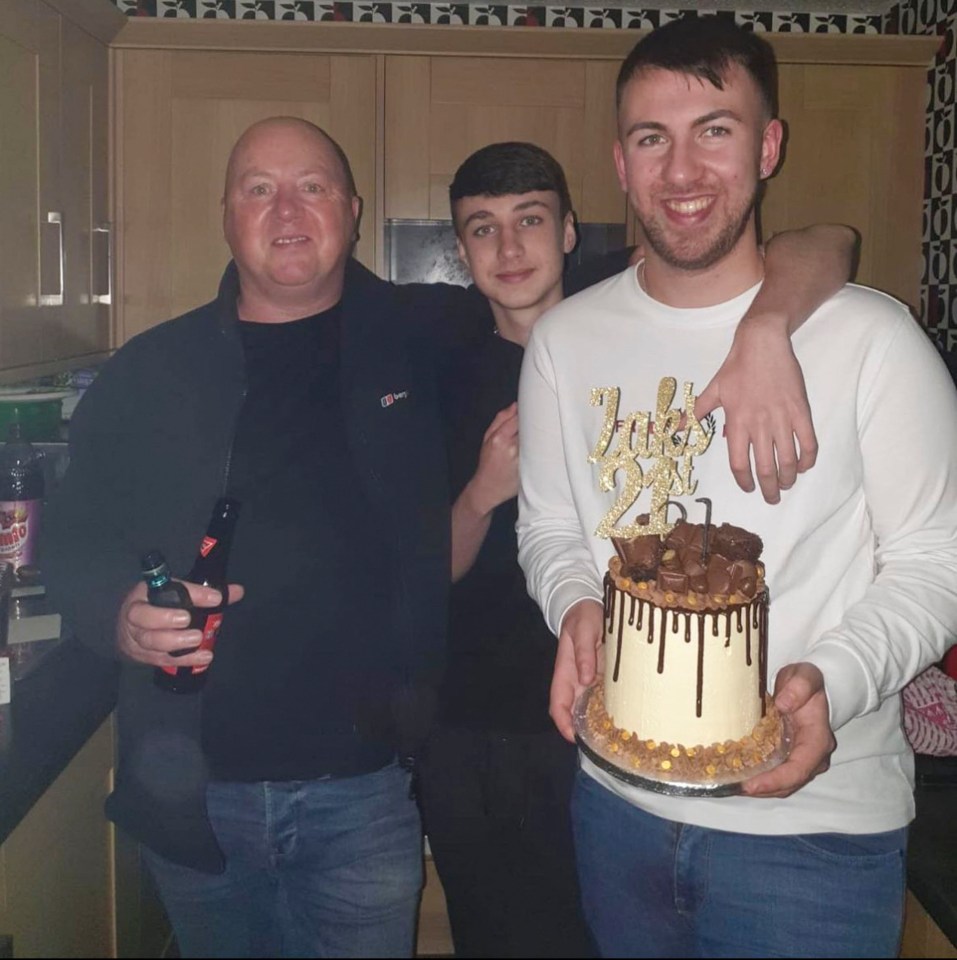 a man holding a cake with the number 20 on it