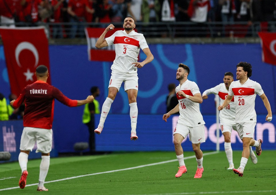 a group of soccer players from turkey jump in the air