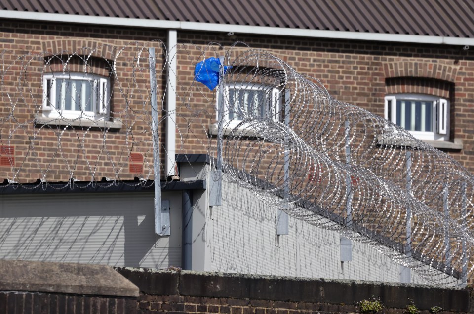 a barbed wire fence surrounds a brick building