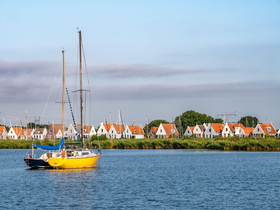 2PWTA39 Skyline of row of houses and dike of Durgerdam village from Buiten IJ river near Amsterdam, Netherlands