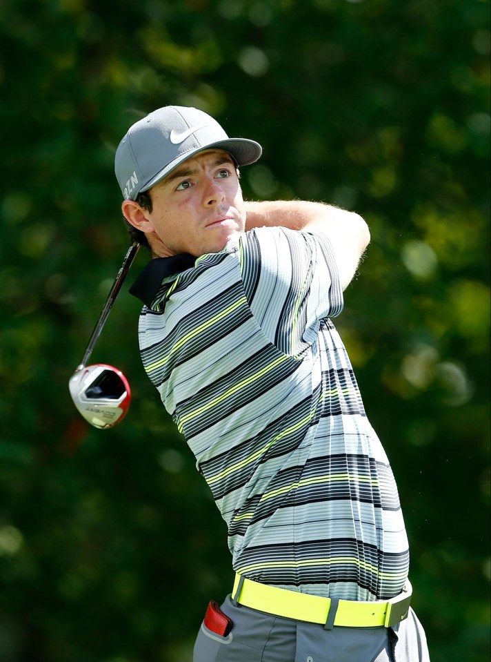 a man wearing a nike hat is swinging a golf club