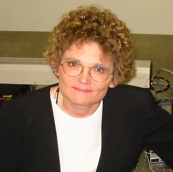 a woman with curly hair is wearing glasses and a black jacket .