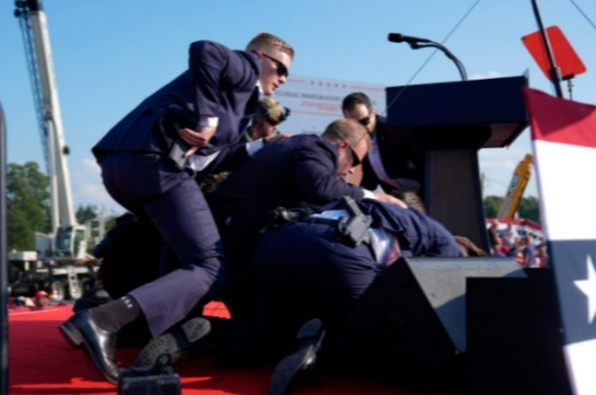 Secret Service agents protect Trump behind the podium