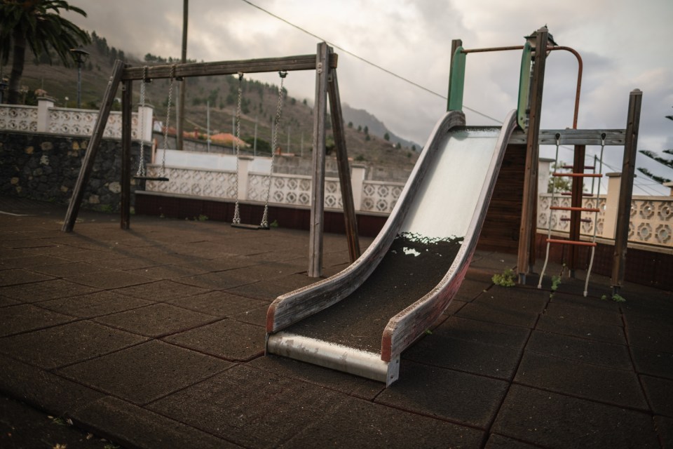 EL PASO, SPAIN - SEPTEMBER 20: Ashes cover a playground as Mount Cumbre Vieja continues to erupt in El Paso, spewing out columns of smoke, ash and lava as seen from Los Llanos de Aridane on the Canary island of La Palma on September 20, 2021. - The Cumbre Vieja volcano erupted on Spain's Canary Islands today spewing out lava, ash and a huge column of smoke after days of increased seismic activity, sparking evacuations of people living nearby, authorities said. Cumbre Vieja straddles a ridge in the south of La Palma island and has erupted twice in the 20th century, first in 1949 then again in 1971. (Photo by Andres Gutierrez/Anadolu Agency via Getty Images)