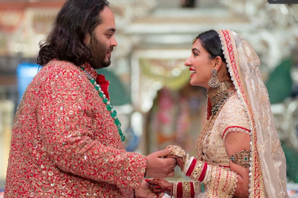 a bride and groom are holding hands and smiling at each other