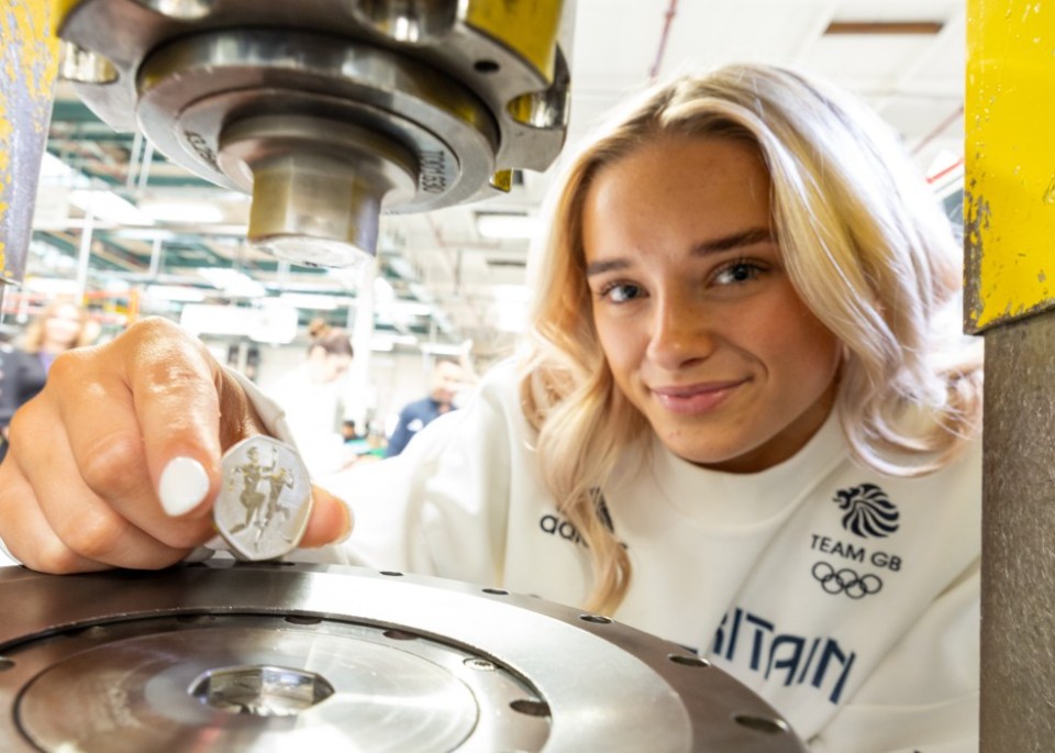 EMBARGOED TO 0001 TUESDAY JULY 02 Undated handout photo issued by the Royal Mint of Team GB gymnast Ruby Evans, in the process of pressing a Royal Mint 50p coin, with a design to commemorate the Paris 2024 Olympic and Paralympic Games. Issue date: Tuesday July 2, 2024. PA Photo. Ruby Evans was one of few athletes invited to strike some of the first coins, to celebrate their release. See PA story MONEY Coin. Photo credit should read: Royal Mint/PA Wire NOTE TO EDITORS: This handout photo may only be used for editorial reporting purposes for the contemporaneous illustration of events, things or the people in the image or facts mentioned in the caption. Reuse of the picture may require further permission from the copyright holder.