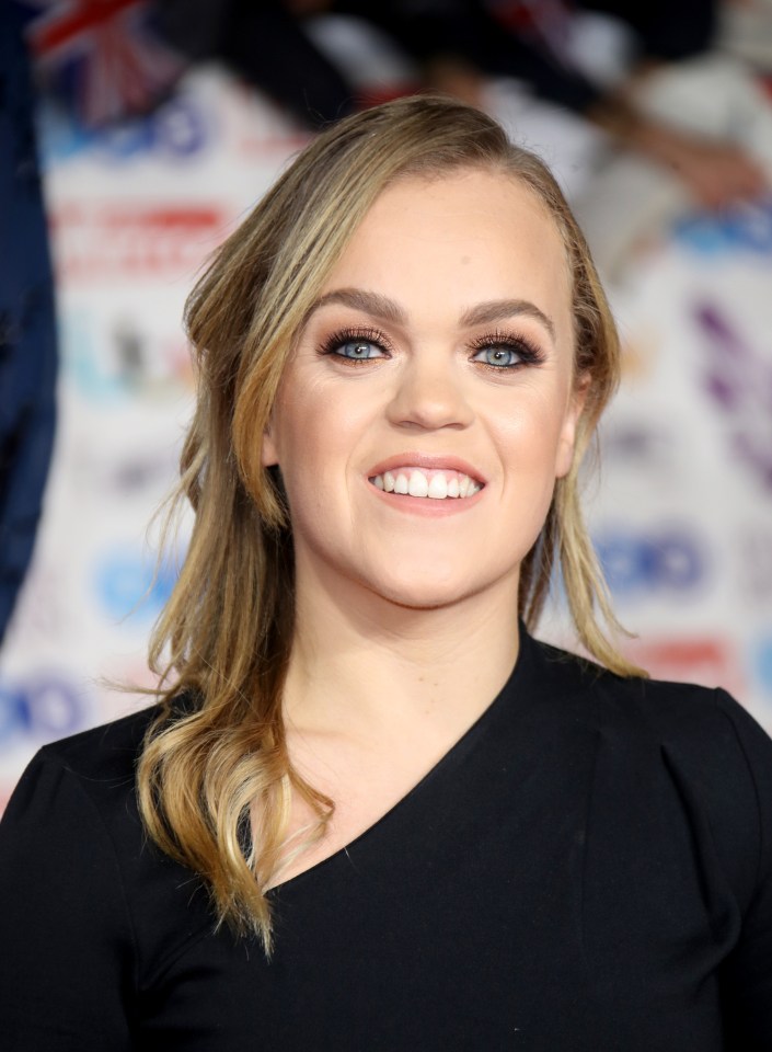 a woman with blonde hair and blue eyes smiles for the camera