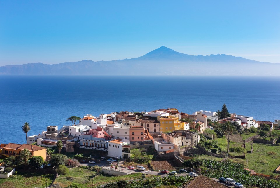 a small town sits on a hill overlooking the ocean