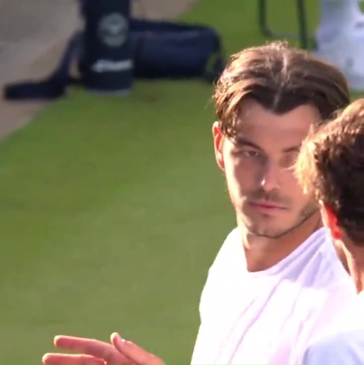 a man in a white shirt is talking to another man