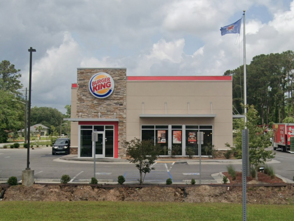 a burger king restaurant with a flag in front of it