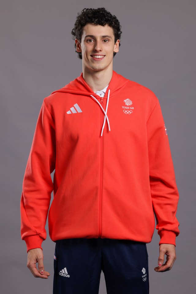 a man wearing a red hoodie that says team gb on it