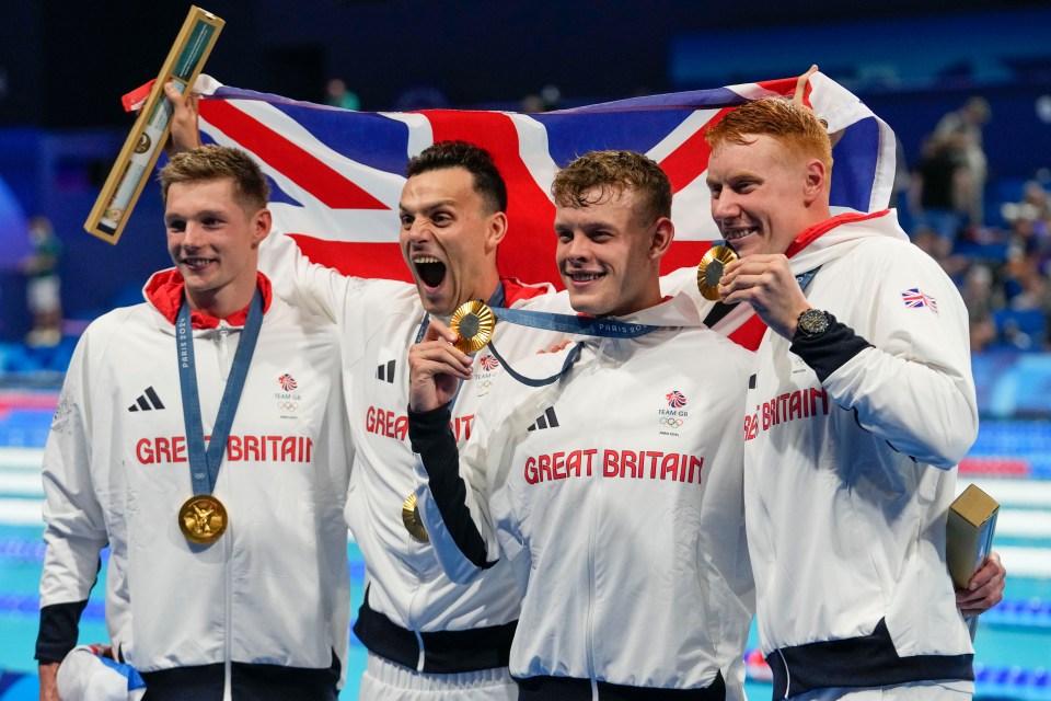 four great britain athletes celebrate with their medals