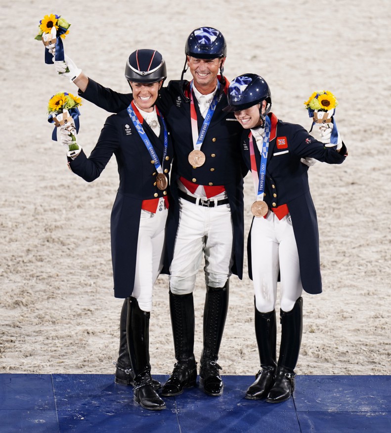 Carl Hester (centre), Charlotte Fry (right) and Charlotte Dujardin (left) celebrate with their Bronze Medals at the Tokyo 2020 Olympic Games