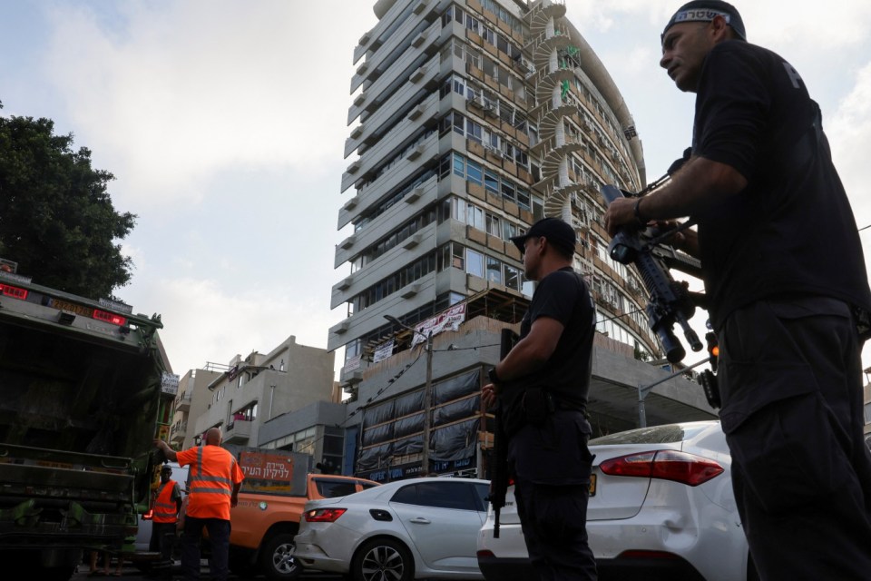 Armed police stand outside a building that was rocked in the blast