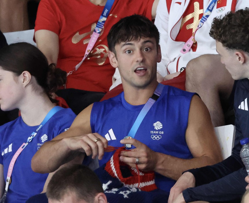 Tom Daley knitting a jumper whilst watching Yasmin Harper and Scarlett Mew Jensen claim Team GB's first medal of the 2024 Olympics