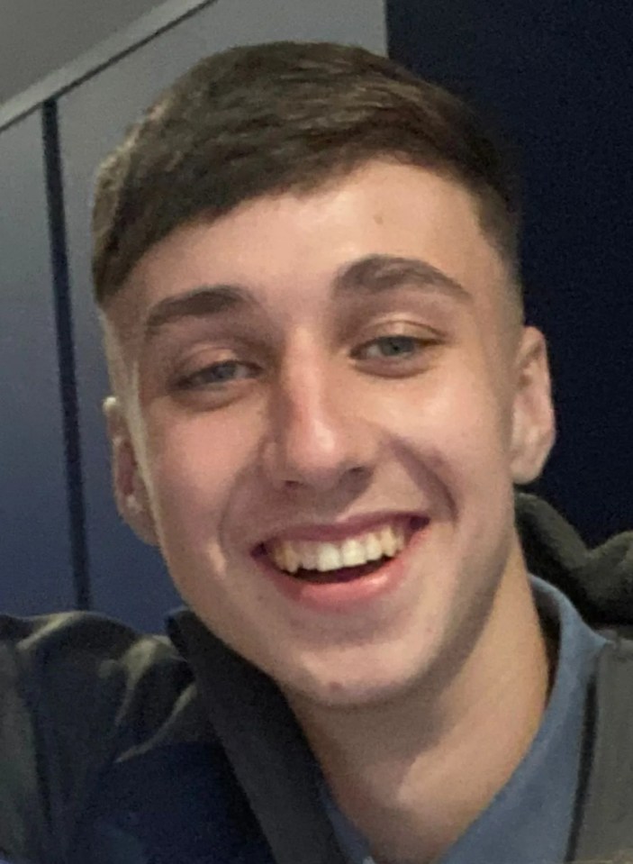 a young man in a blue shirt smiles for the camera