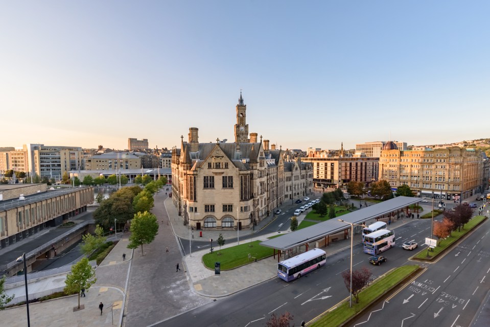 an aerial view of a city with a double decker bus in the foreground