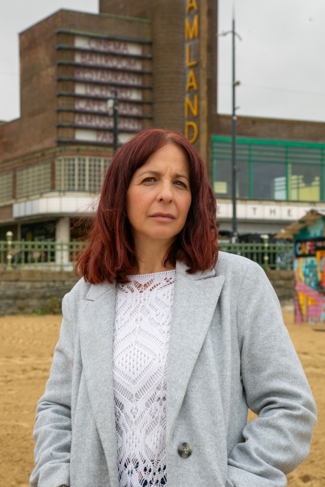 a woman stands in front of a building that says amland