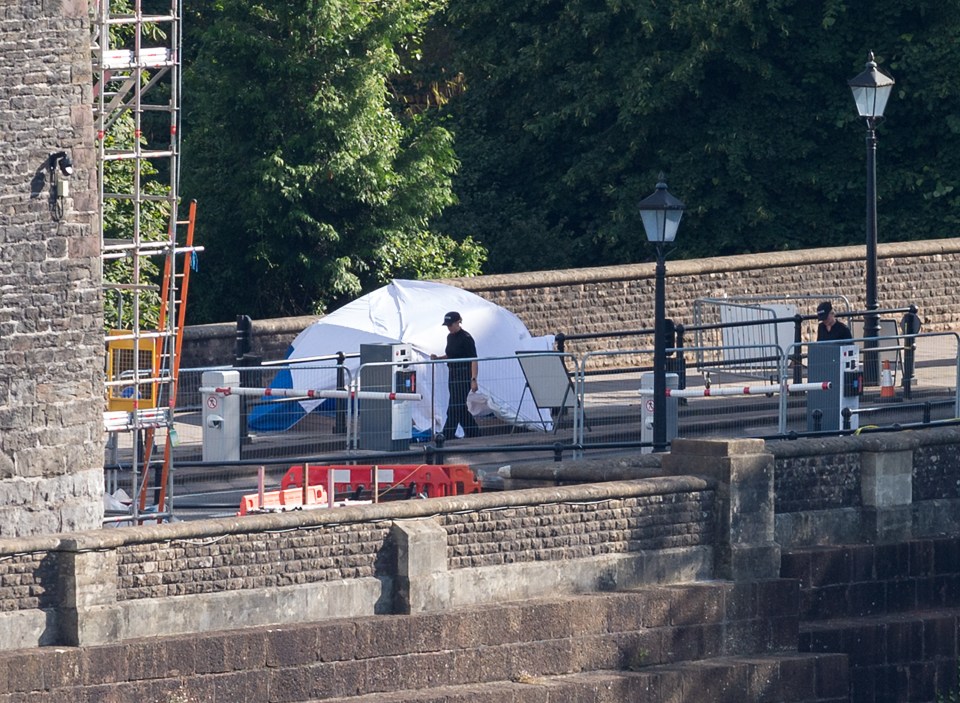 a police officer stands in front of a white tent