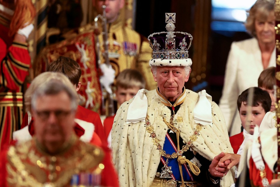 a man in a crown holds a child 's hand