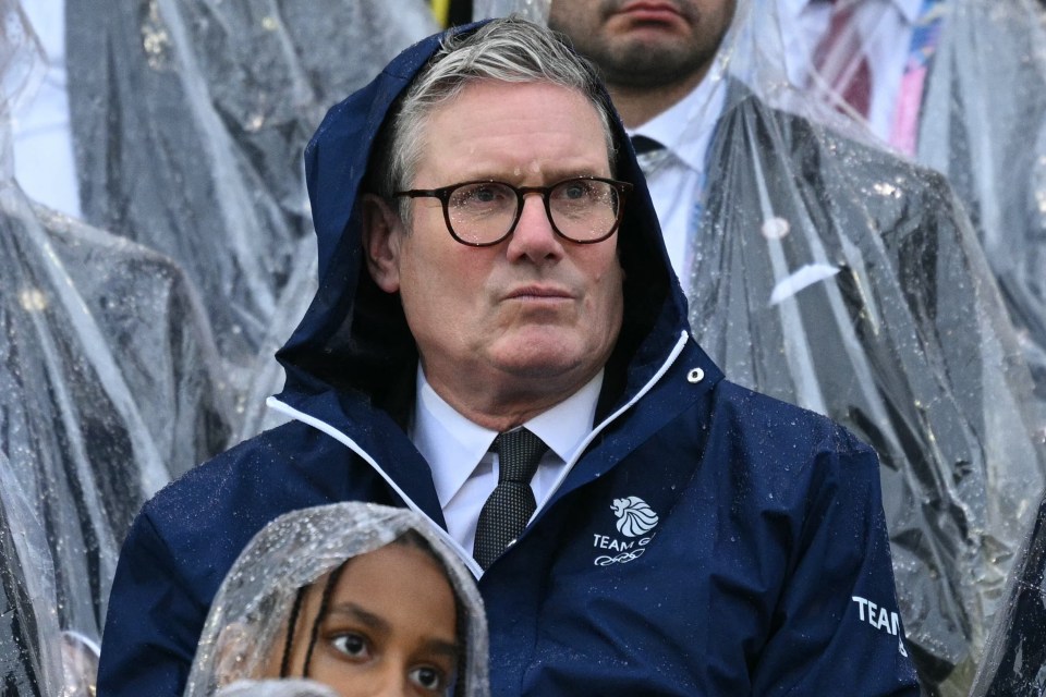 A wet Sir Keir Starmer watched from the stands