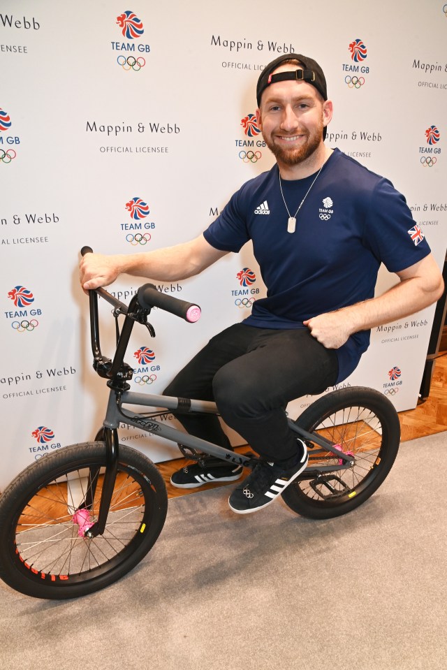 a man riding a bike in front of a wall that says mappin & webb