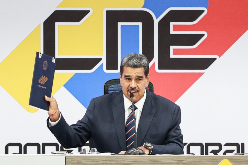 Maduro shows his supporters the certificate proclaiming him as the winner of the election