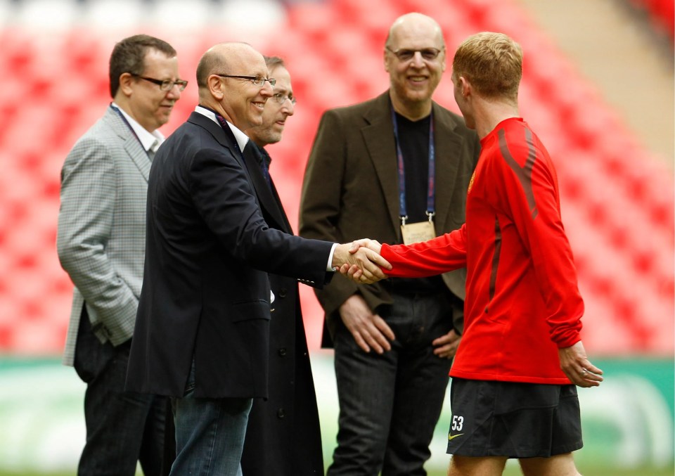 Joel Glazer shaking hands with United legend Paul Scholes at the team's training ground in May 2011