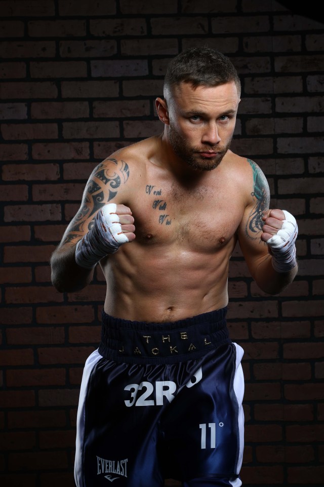 a boxer wearing a pair of everlast shorts stands in front of a brick wall