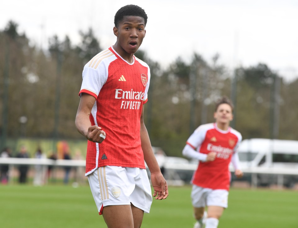 a soccer player wearing a red emirates fly better jersey