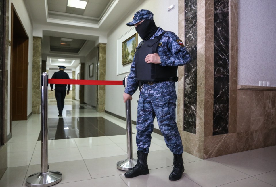 a man in a military uniform is standing in a hallway