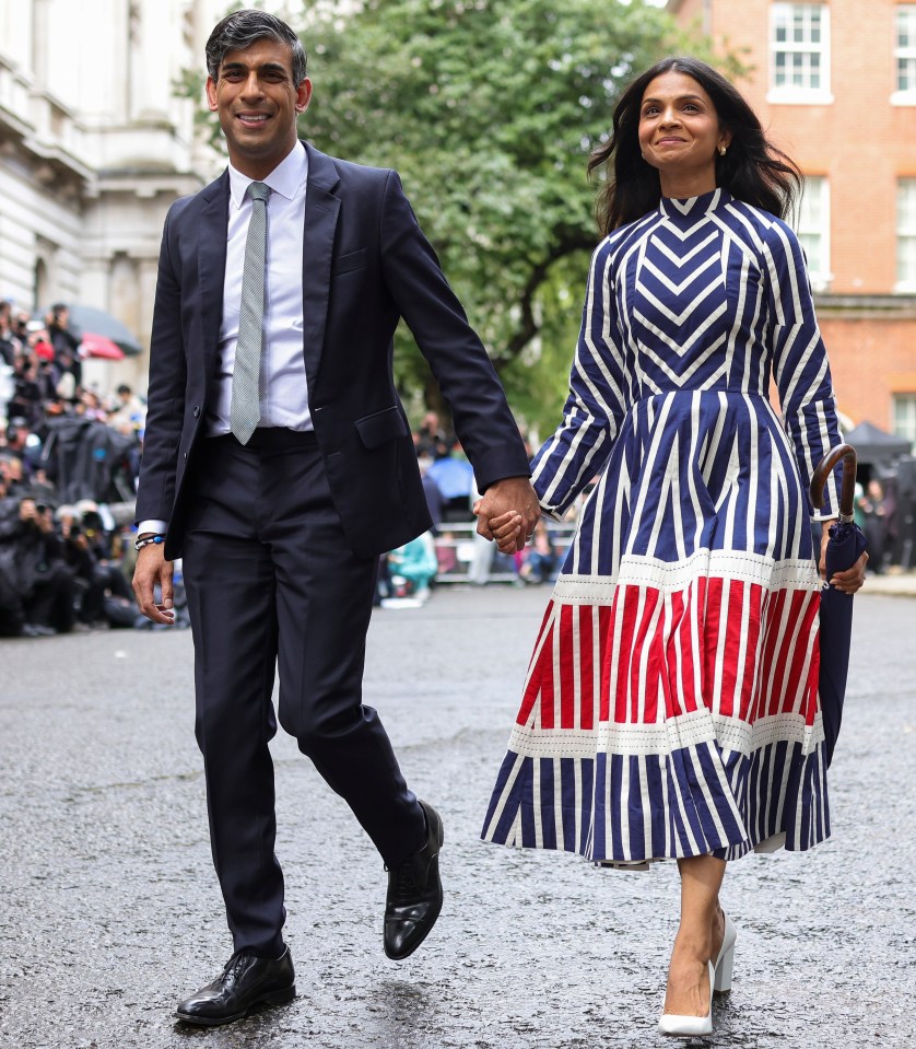 a man in a suit and tie holds hands with a woman in a striped dress