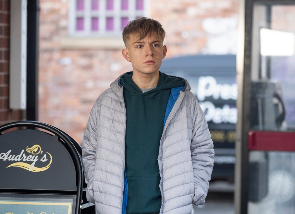 a young man stands in front of a sign that says andrey 's