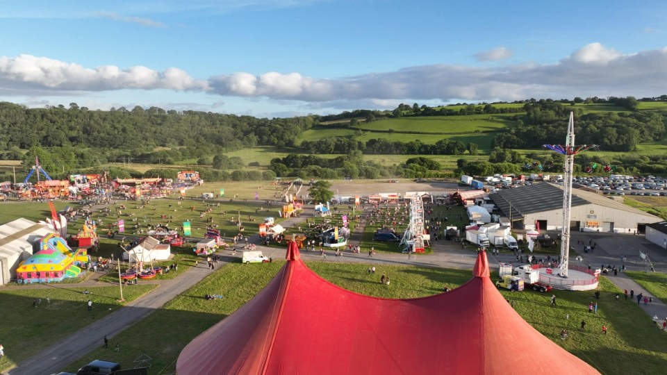 an aerial view of a carnival with a red tent in the foreground