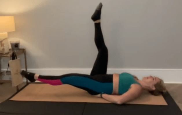 Alternate lowering your legs towards the floor in a scissoring motion