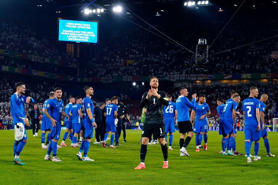 a group of soccer players standing on a field with a screen behind them that says uefa euro 2004