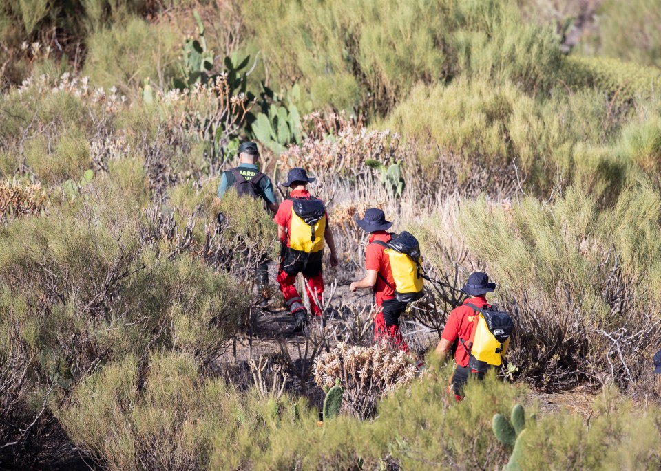 a group of people walking through a field with one wearing a badge