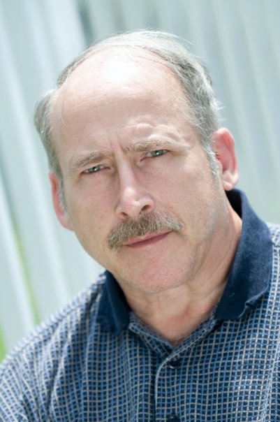 a bald man with a mustache is wearing a blue shirt