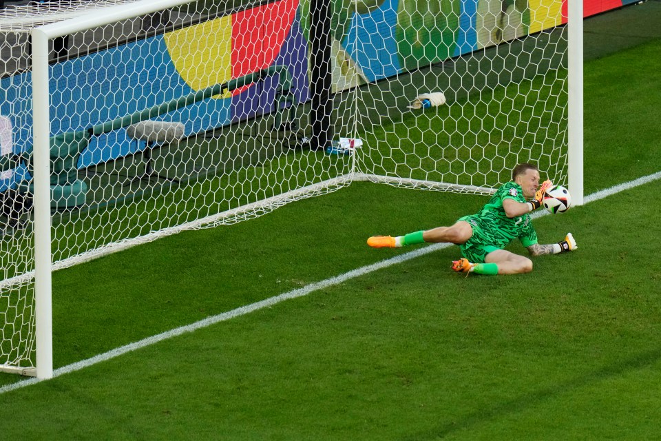 a soccer goalie dives to catch a soccer ball