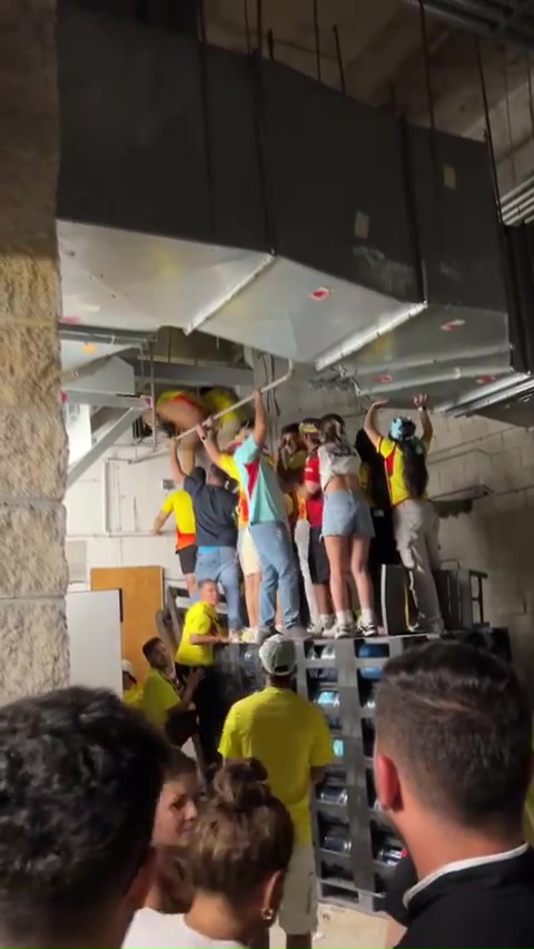 a group of people are standing on a ladder in a room .