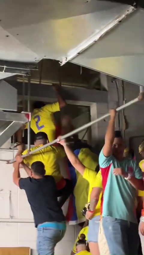 a group of people are hanging from the ceiling and one of them has the number 2 on his shirt .