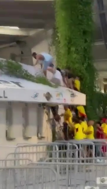 a group of people are standing on top of a building .