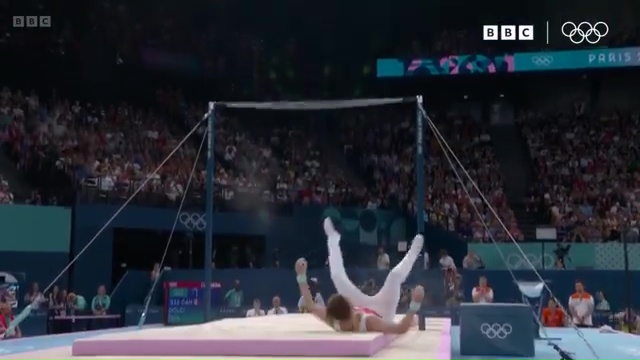 a gymnast is doing a handstand on a mat in front of a crowd .