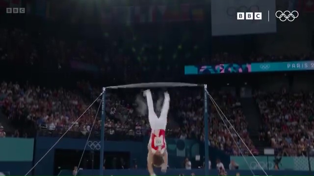 a gymnast performs a handstand on a bar at the olympics