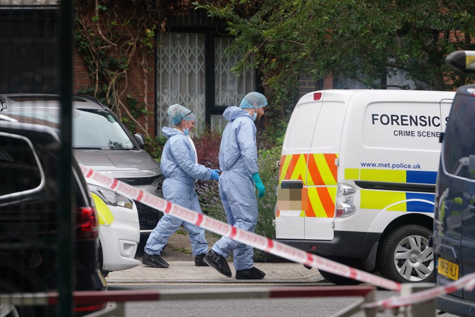 two forensic officers are walking in front of a forensic van