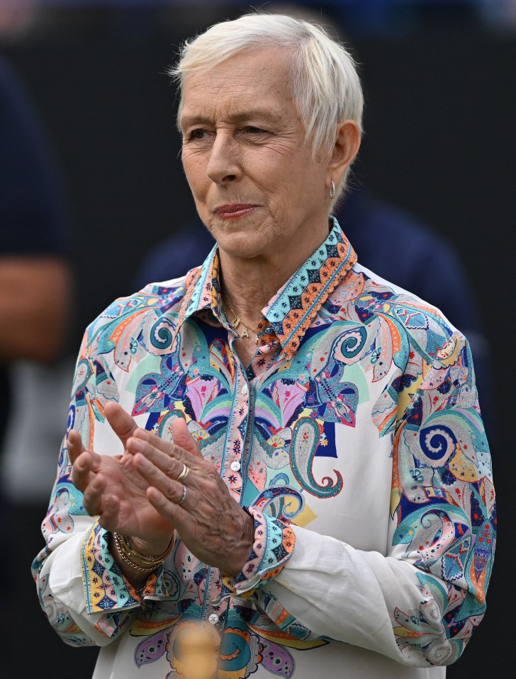 a woman wearing a colorful shirt is clapping her hands