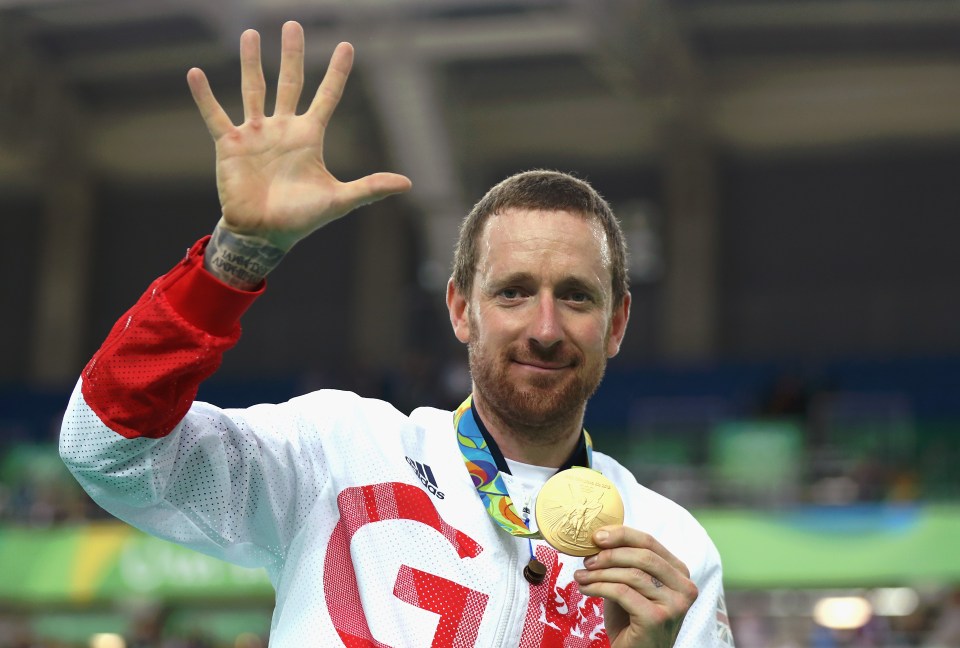 a man holding a gold medal that has the letter g on it