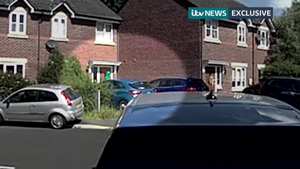 a silver car is parked in front of a row of brick houses