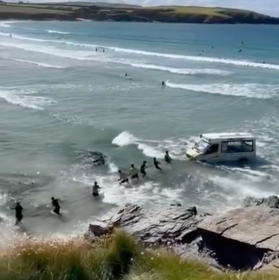 Beachgoers formed a tug-o-war team to try to pull the van to safety