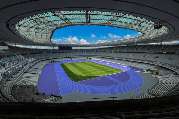 an empty stadium with a blue track in the middle